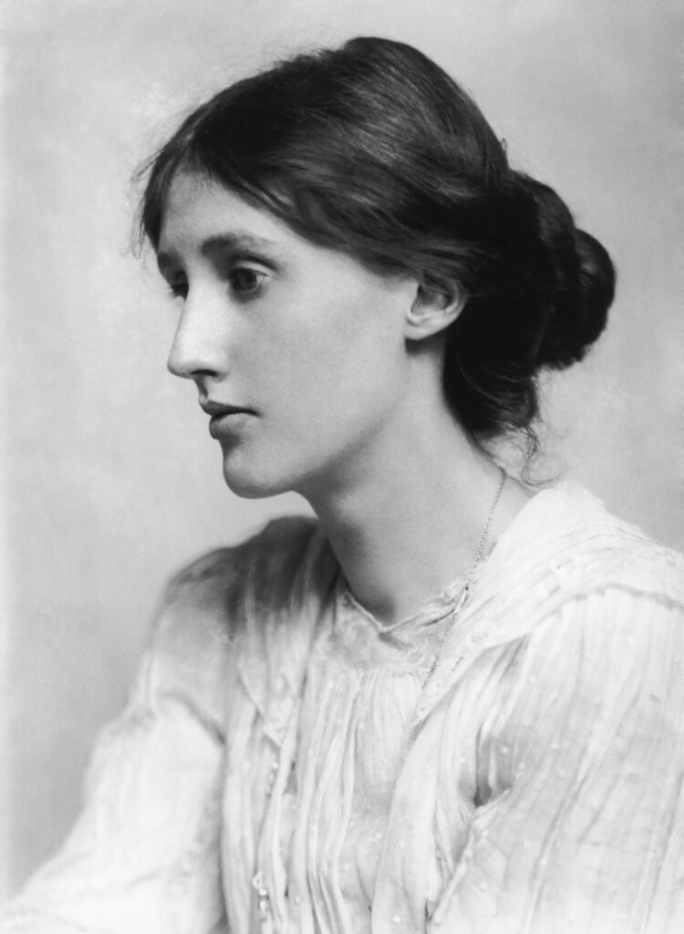 Schwarz-Weiß-Aufnahme von Virginia Woolf, sitzend in einem Sessel, nachdenklicher Blick zur Seite, um 1927.