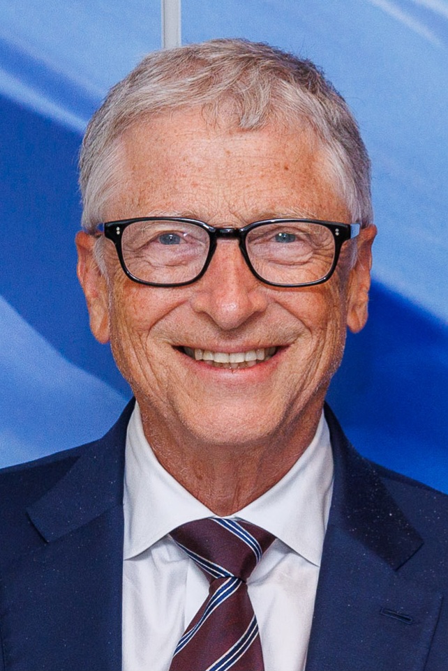Bill Gates während einer Rede auf einer Konferenz, aufgenommen in den frühen 2000er Jahren, mit fokussiertem Blick.