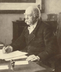 Otto von Bismarck in der Uniform seines Kürassier-Regiments, stehend neben einem Schreibtisch, eine Fotografie aus der Zeit um 1890.