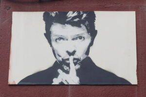 David Bowie als sein Alter Ego Ziggy Stardust während eines Konzerts, 1973, mit rot gefärbtem Haar und extravagantem Make-up.
