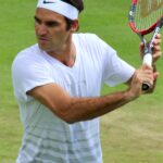 Roger Federer bei einem Aufschlag während der Wimbledon Championships, seine Bewegung in voller Streckung zeigend, um 2017.