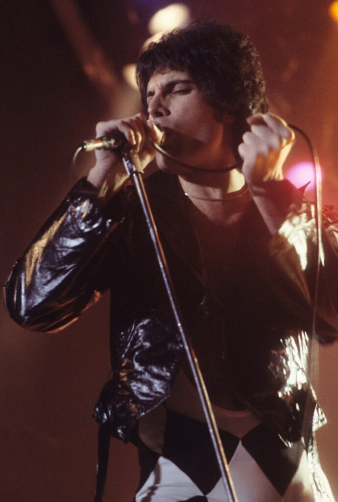 Freddie Mercury auf der Bühne des Wembley-Stadions während des Live Aid Konzerts am 13. Juli 1985 in seiner ikonischen Pose mit erhobener Faust.