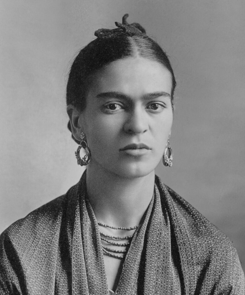 Frida Kahlo in traditioneller mexikanischer Kleidung, umgeben von Blättern, in einer undatierten Fotografie von Nickolas Muray.