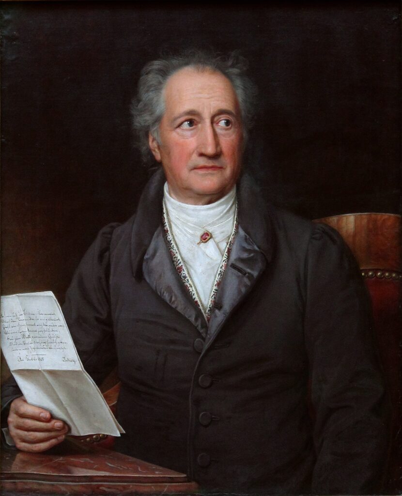 Johann Wolfgang von Goethe im Alter, sitzend in einem Sessel mit dunklem Mantel, gemalt von Joseph Karl Stieler im Jahr 1828.