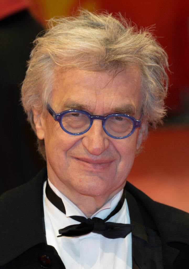Filmregisseur Wim Wenders in einer nachdenklichen Pose, eine charakteristische Schwarzweißaufnahme des deutschen Autorenfilmers bei einem Festival.