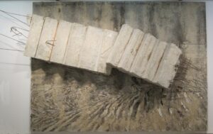 Der Künstler Anselm Kiefer in seinem Atelier, umgeben von großformatigen Leinwänden und Materialien, die für sein Werk charakteristisch sind.