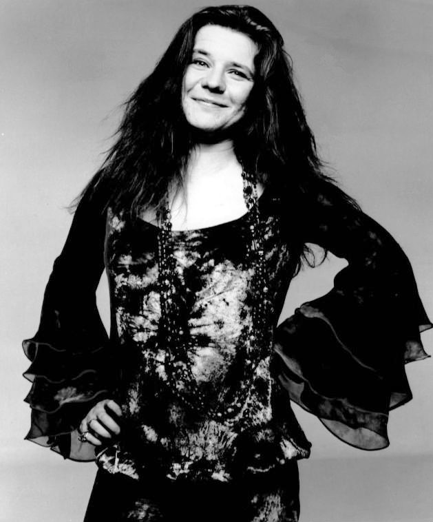 Janis Joplin bei einem Live-Auftritt um 1969, mit Mikrofon in der Hand und ihrer charakteristischen, leidenschaftlichen Mimik.