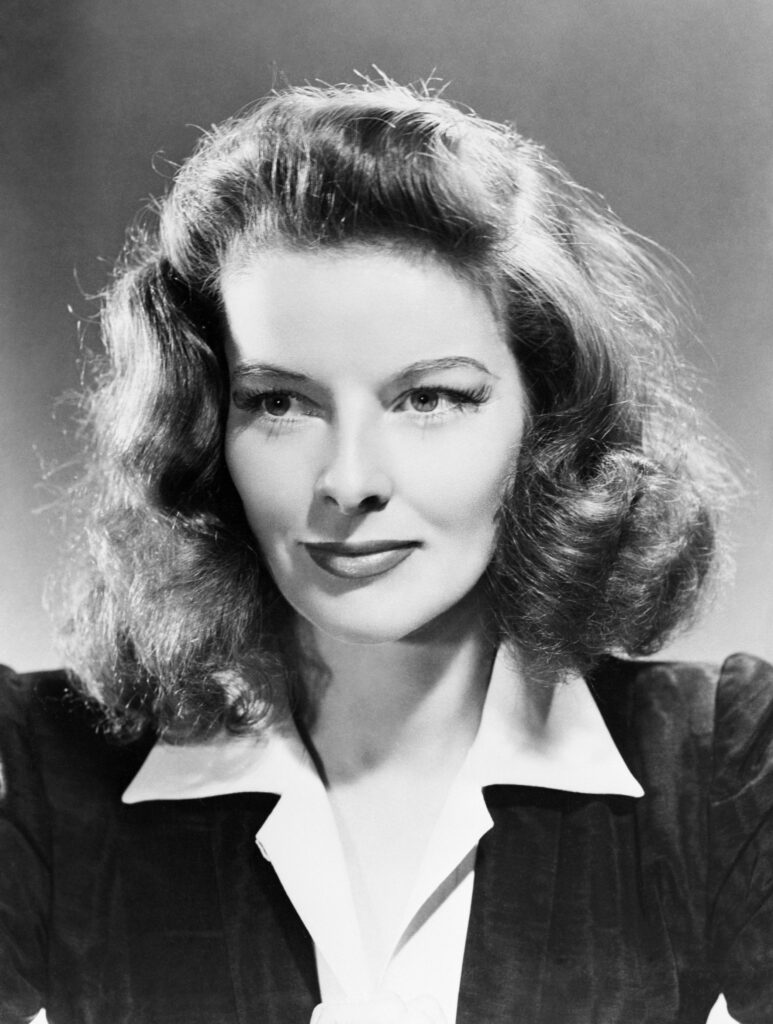 Katharine Hepburn in einer Studioaufnahme um 1940, bekannt für ihren selbstbewussten Blick und ihre charakteristische Haltung.