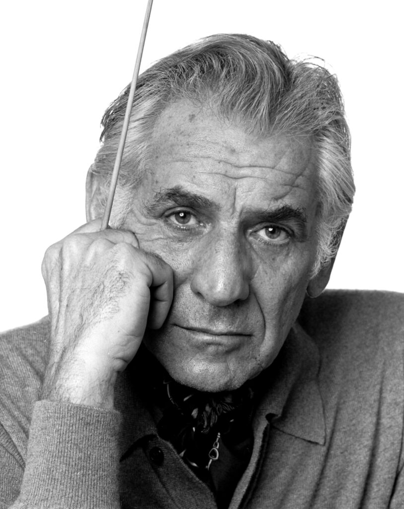 Leonard Bernstein dirigiert mit expressiver Geste und geschlossenen Augen, eine Schwarz-Weiß-Aufnahme während eines Konzerts in den 1960er-Jahren.
