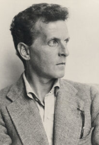 Ludwig Wittgenstein in einer undatierten Porträtaufnahme, die den Philosophen in nachdenklicher Haltung mit intensivem Blick zeigt.