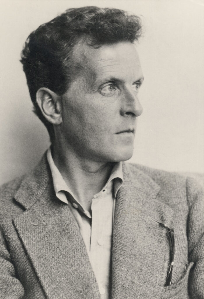 Ludwig Wittgenstein in einer undatierten Porträtaufnahme, die den Philosophen in nachdenklicher Haltung mit intensivem Blick zeigt.