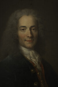 Marmorbüste von Voltaire, gefertigt von Jean-Antoine Houdon, die den alternden Denker mit einem scharfen und ironischen Blick zeigt.