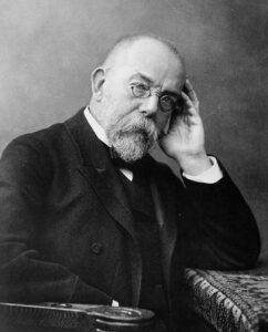 Der Mediziner Robert Koch in seinem Labor, sitzend am Mikroskop, eine undatierte Fotografie aus seiner Berliner Zeit um 1900.