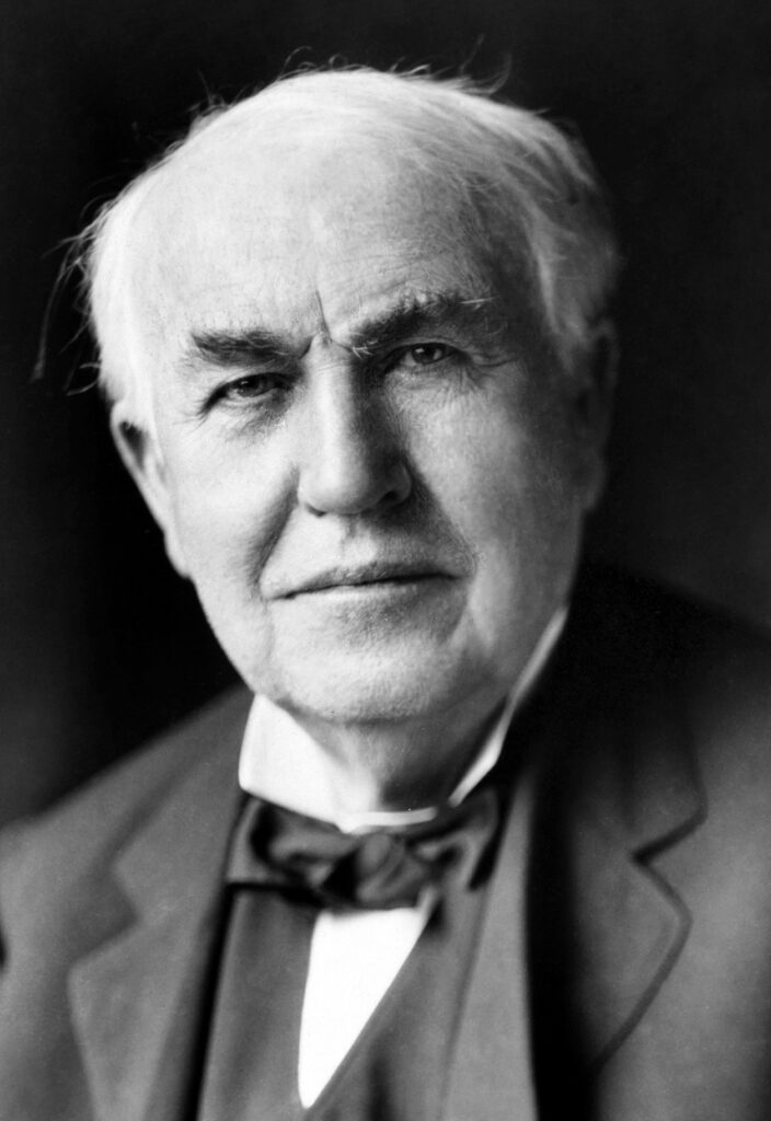 Thomas Alva Edison in seinem Labor in West Orange um 1911, neben einem Phonographen und chemischen Apparaturen.