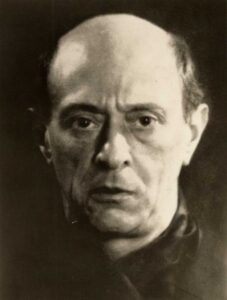 Der Komponist Arnold Schönberg in einer undatierten Porträtaufnahme um 1925, nachdenklich blickend, mit Hemd und Krawatte.