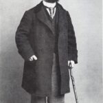 Henri de Toulouse-Lautrec in seinem Pariser Atelier um 1894, stehend vor einer Staffelei mit Pinsel und Palette in der Hand.