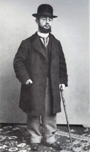 Henri de Toulouse-Lautrec in seinem Pariser Atelier um 1894, stehend vor einer Staffelei mit Pinsel und Palette in der Hand.