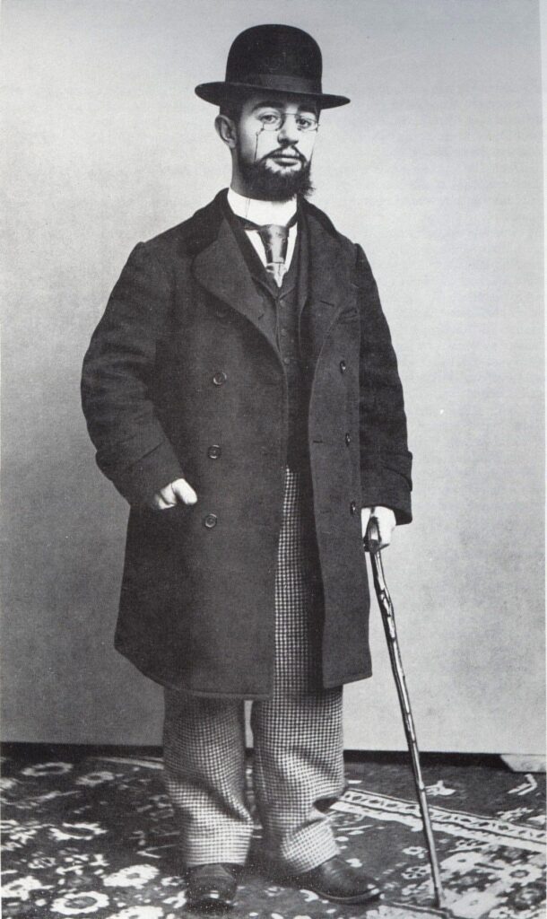 Henri de Toulouse-Lautrec in seinem Pariser Atelier um 1894, stehend vor einer Staffelei mit Pinsel und Palette in der Hand.