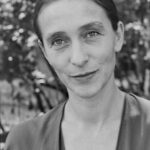 Die Choreografin Pina Bausch während einer Probe, konzentriert im Gespräch mit ihrem Ensemble, undatierte Aufnahme aus den späten 1980er-Jahren.