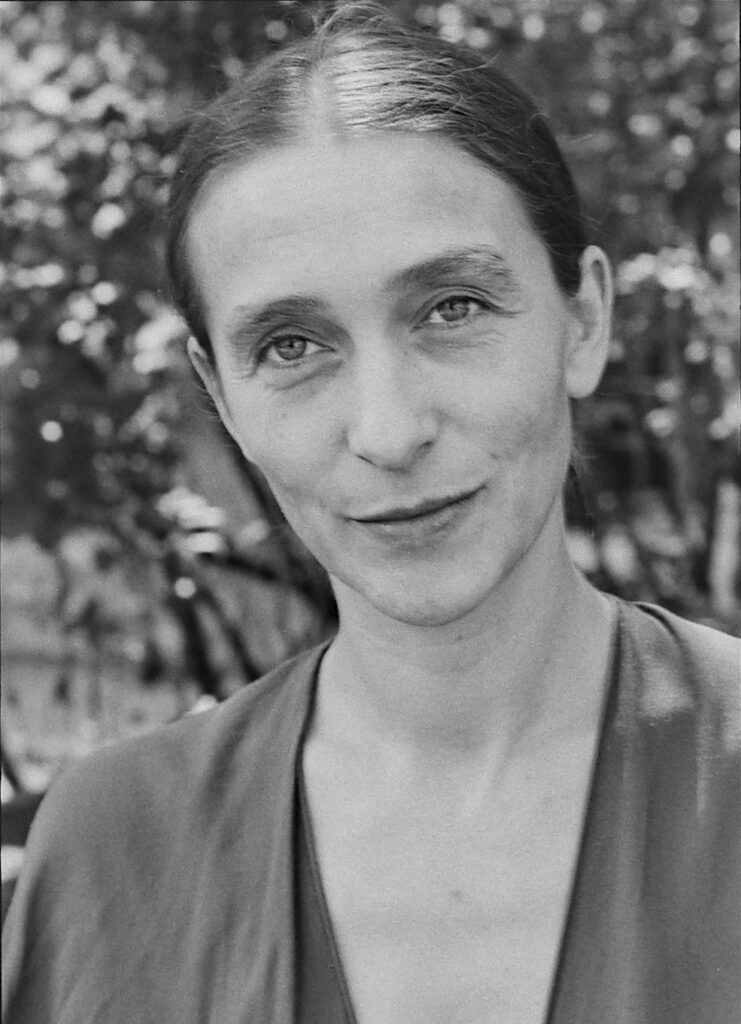 Die Choreografin Pina Bausch während einer Probe, konzentriert im Gespräch mit ihrem Ensemble, undatierte Aufnahme aus den späten 1980er-Jahren.