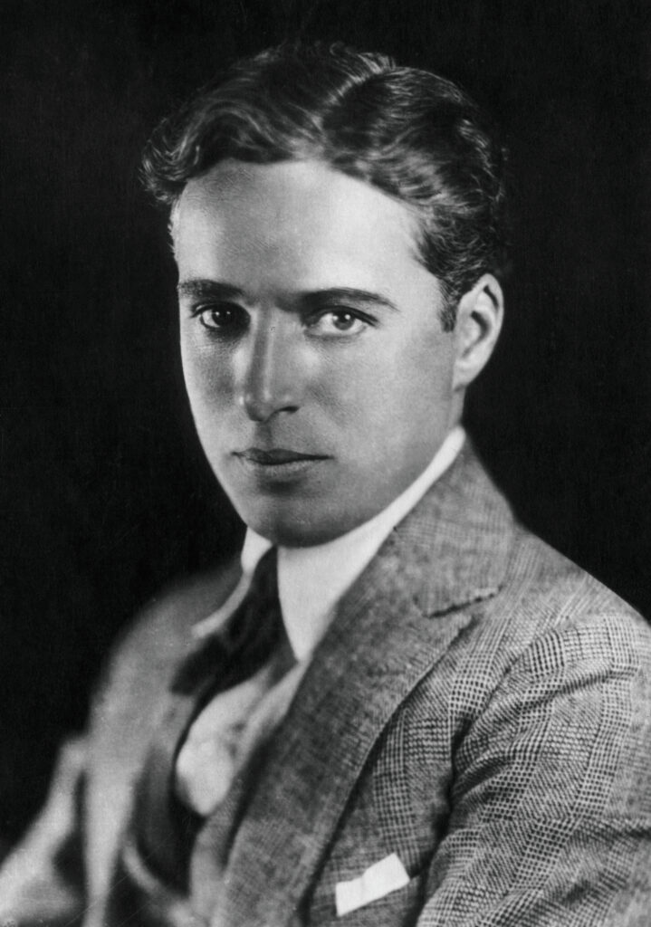 Charlie Chaplin in seiner berühmten Rolle als 'Tramp', mit Melone, Stock und Schnurrbart, in einer Szene aus einem seiner Stummfilme um 1925.