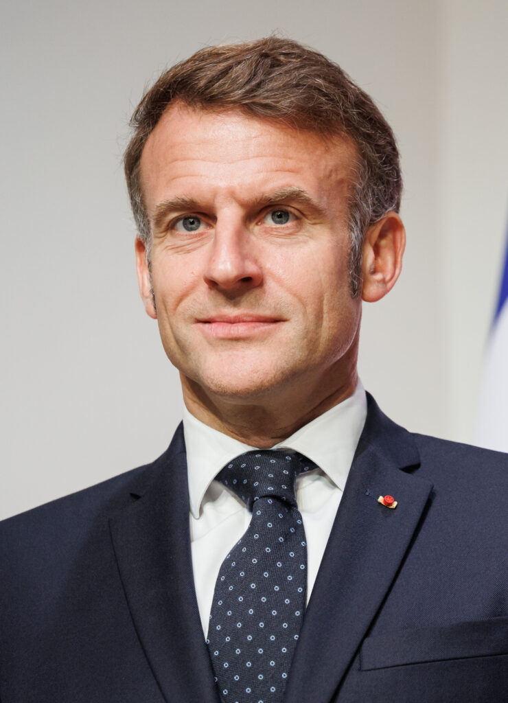 Emmanuel Macron während einer offiziellen Rede im Élysée-Palast in Paris, umgeben von der französischen und der europäischen Flagge.