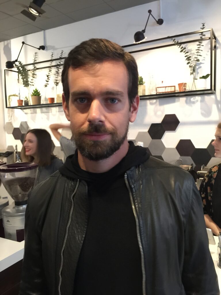 Der Unternehmer Jack Dorsey bei einer öffentlichen Veranstaltung, nachdenklich blickend, in seinem typischen minimalistischen Stil gekleidet.