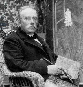 Schwarz-Weiß-Fotografie von Henri Rousseau in seinem Pariser Atelier, umgeben von seinen Gemälden, aufgenommen um 1907.