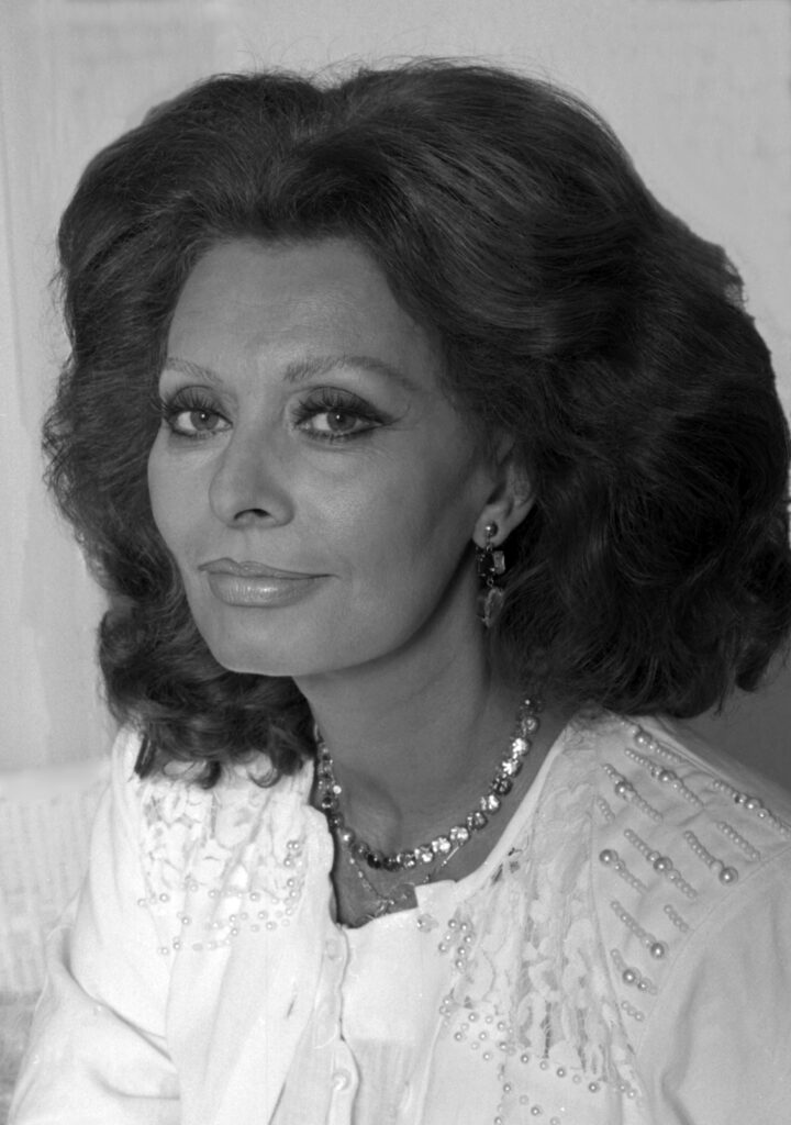 Die italienische Schauspielerin Sophia Loren in einer Porträtaufnahme um 1960, mit charakteristischem Blick und elegantem Make-up, das ihre Leinwandpräsenz unterstreicht.