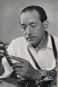 Der japanische Filmregisseur Yasujirō Ozu am Filmset, konzentriert blickend, in einer undatierten Aufnahme aus den 1950er-Jahren.